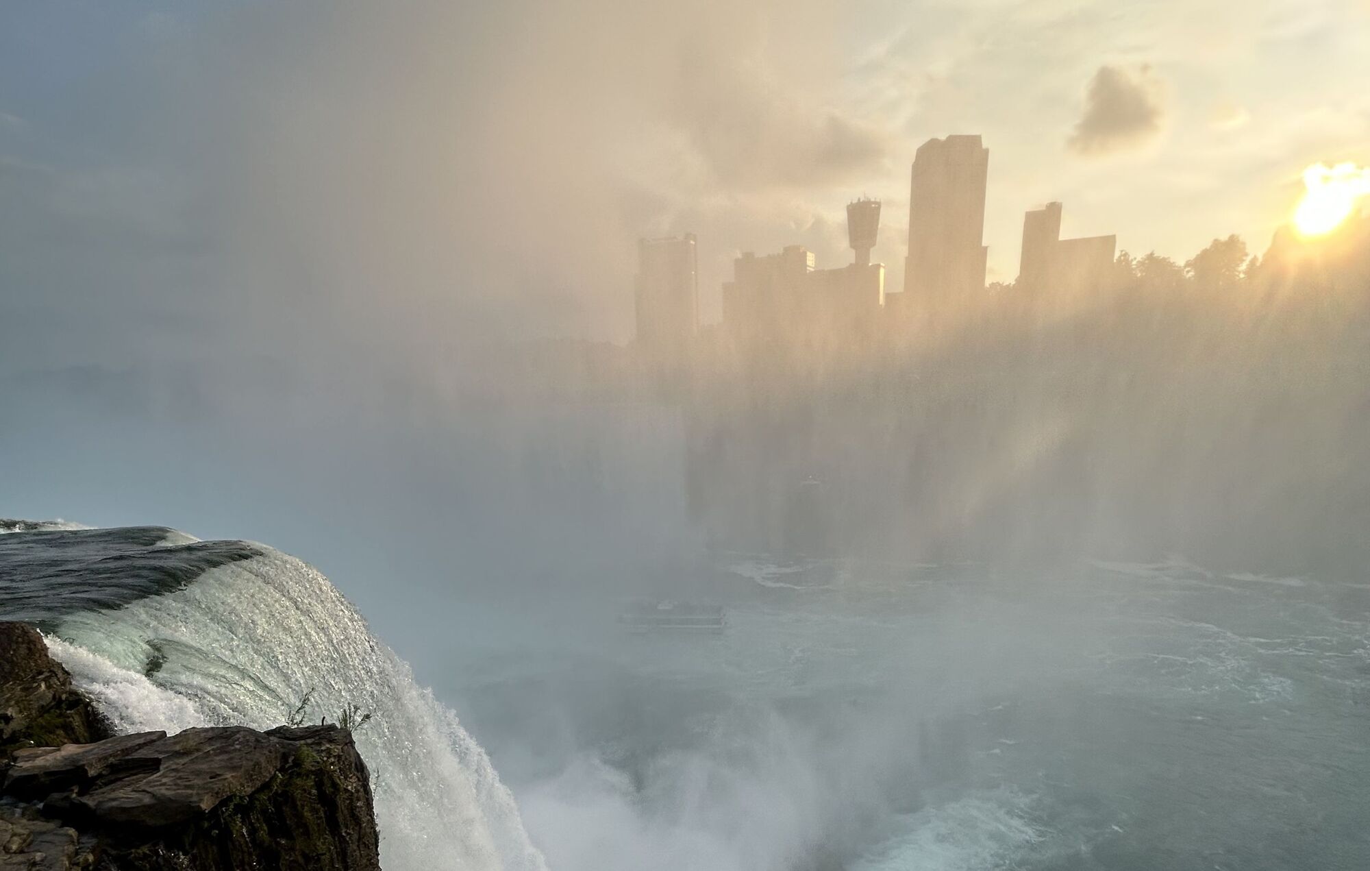 Waterfall with city in the foggy distance